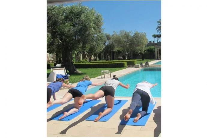Pilates students exercising outside at the pool in the Italian sun