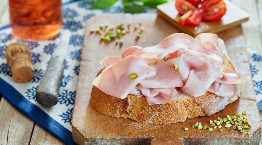 Mortadella sitting on a slice of bread