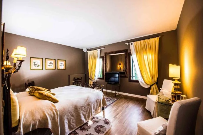 A bedroom in Villa Domenica with flowing drapes and warm light