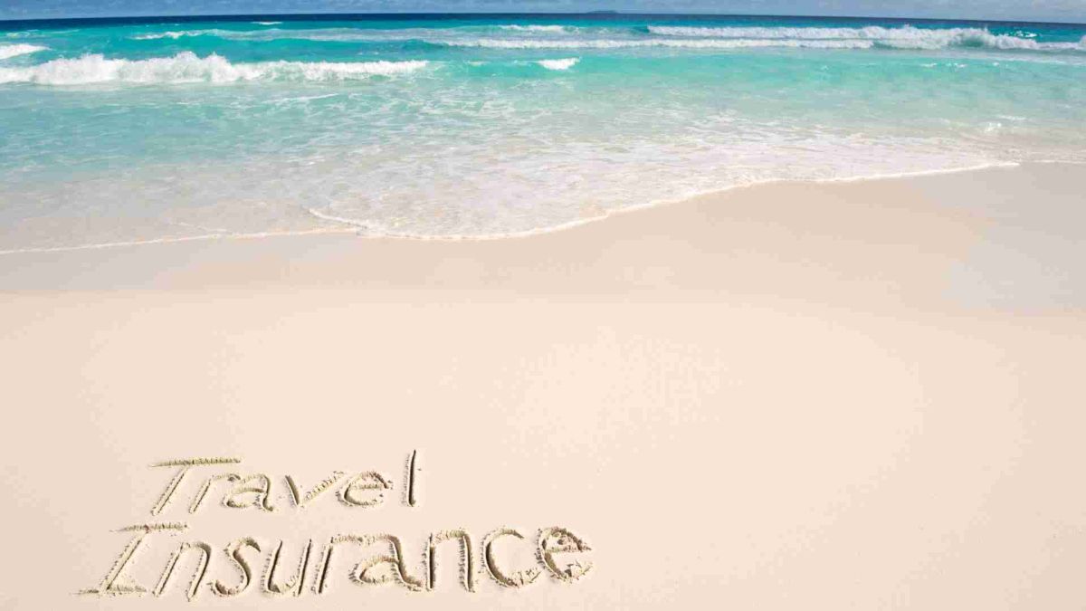 travel insurance written in the sand